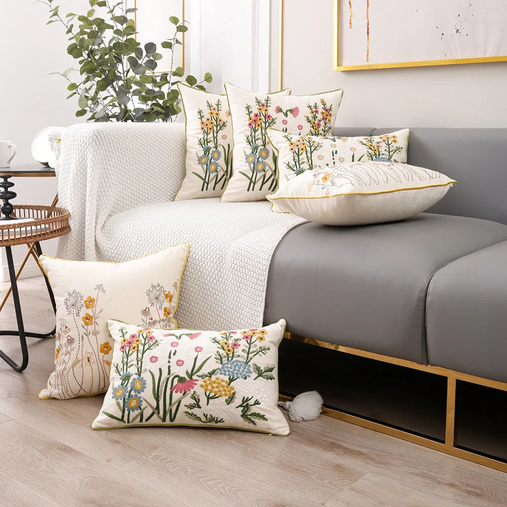 Cette chambre confortable est décorée avec des coussins décoratifs aux motifs floraux colorés et une couverture en tricot, créant une atmosphère chaleureuse et accueillante.