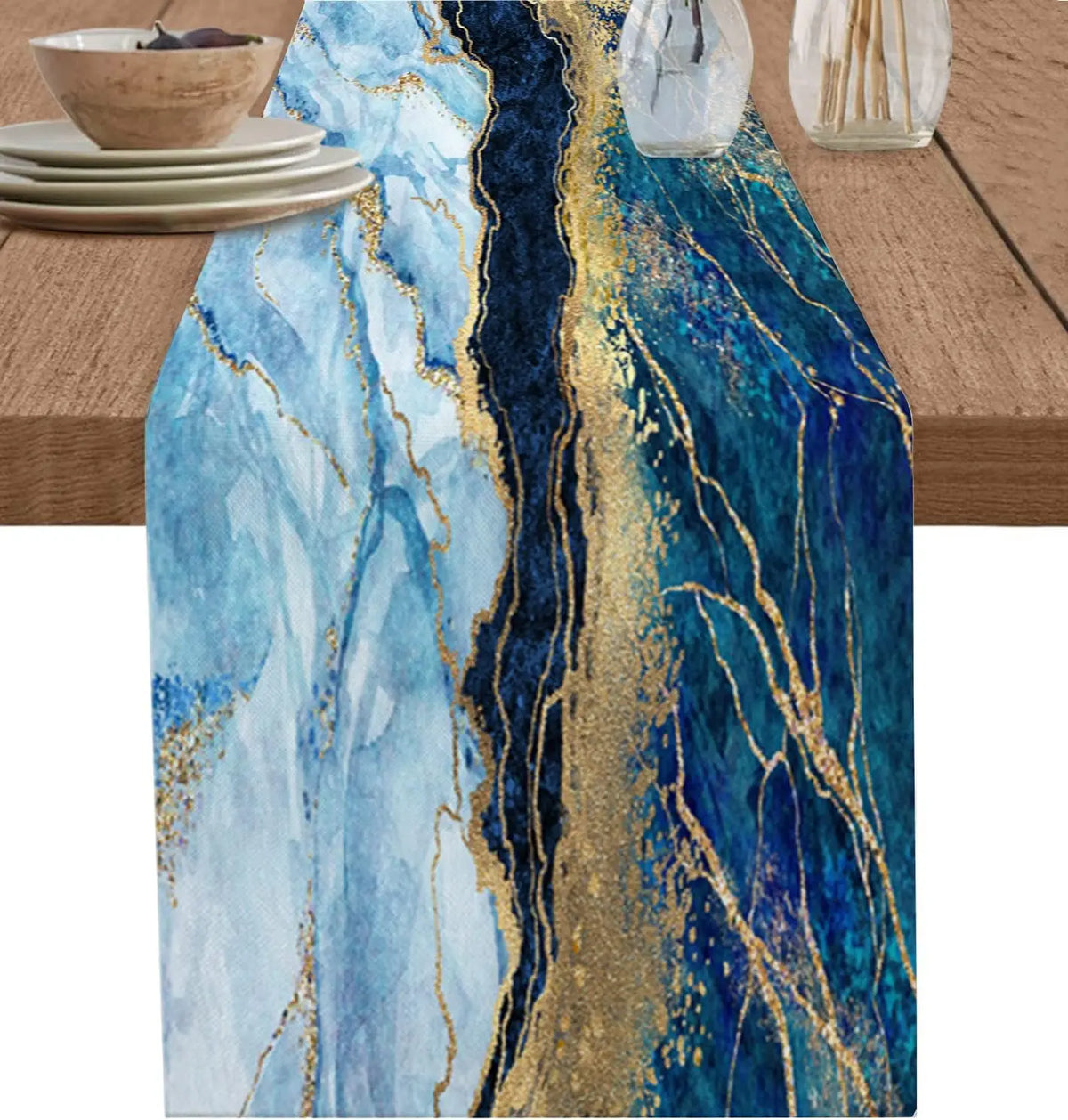 Une somptueuse nappe en tissu bleu ciel et doré, ornée de veines marbrées élégantes, qui crée une ambiance chaleureuse et sophistiquée pour la table.
