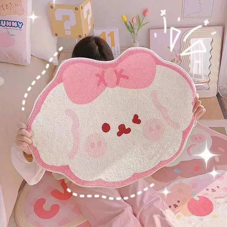 Une peluche douce et rose en forme de personnage mignon avec un nœud et des détails rouges, dans un environnement décoré avec des éléments ludiques.