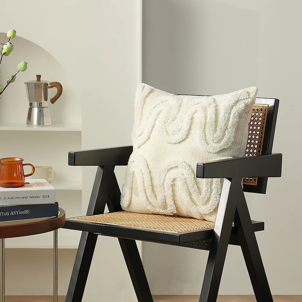 Fauteuil confortable en bois avec coussin moelleux et texture intéressante, entouré de livres sur une table basse dans un environnement intérieur lumineux.