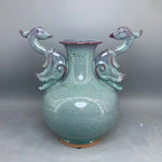 Vase en céramique vintage aux motifs de poissons stylisés en relief et à la texture granuleuse dans des teintes de vert bleuté.