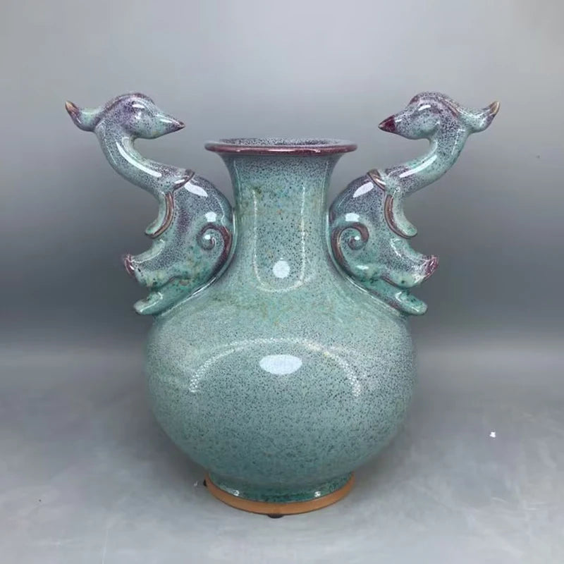 Vase en céramique vintage aux motifs de poissons stylisés en relief et à la texture granuleuse dans des teintes de vert bleuté.