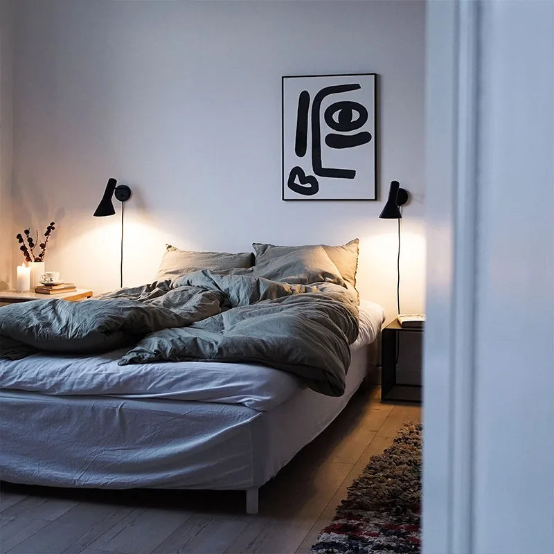 Applique murale minimaliste blanche au-dessus d'un lit