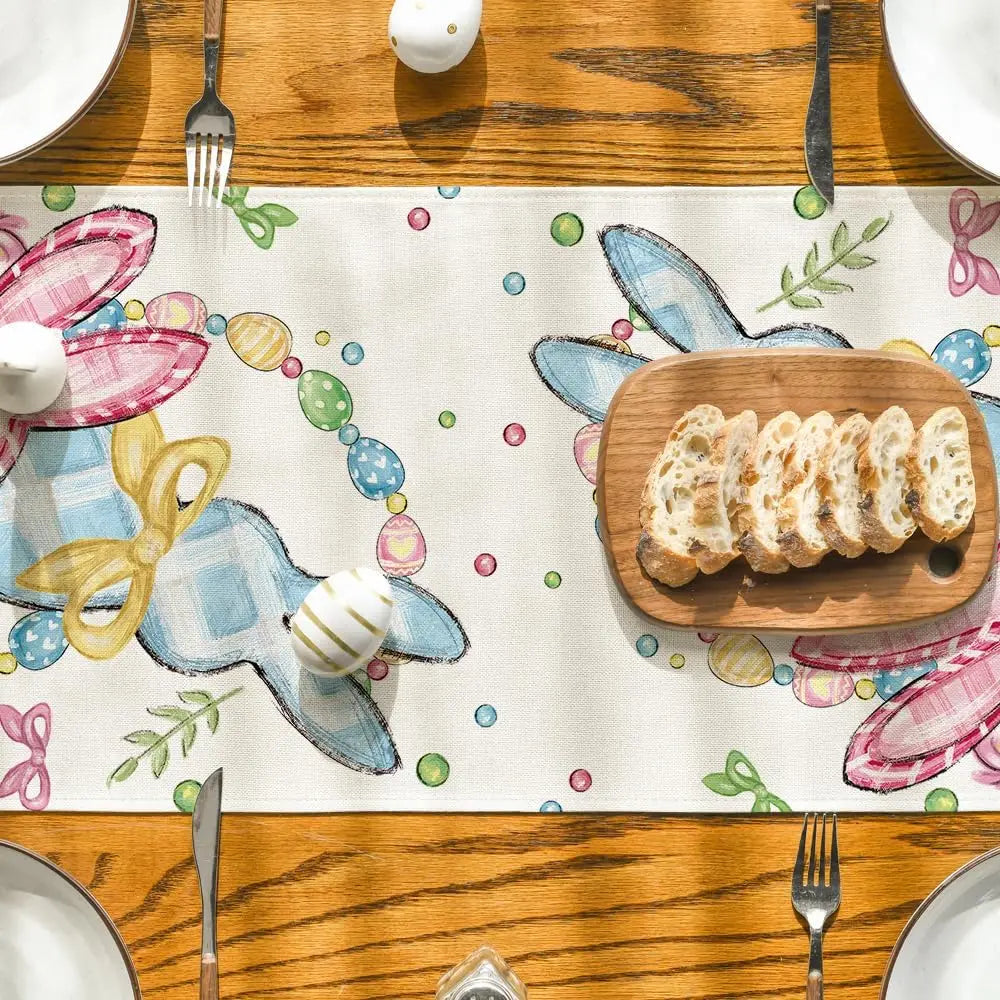 Une table en bois avec un motif coloré de Pâques, décorée de couverts et d'un morceau de pain doré.