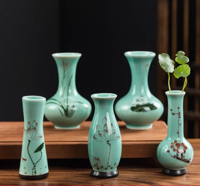 Cette image présente une belle collection de vases décoratifs en céramique vert pâle ornés de motifs floraux délicats.