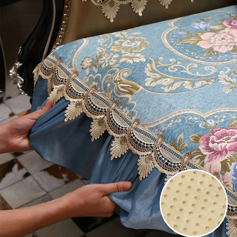 Coussin décoratif bleu clair avec des motifs floraux dorés et une bordure en dentelle beige, créant une élégance raffinée dans l'intérieur.