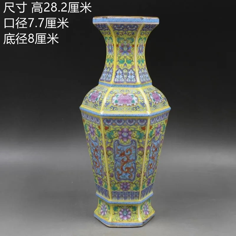 Vase en porcelaine décoré de motifs floraux colorés sur un fond jaune éclatant.