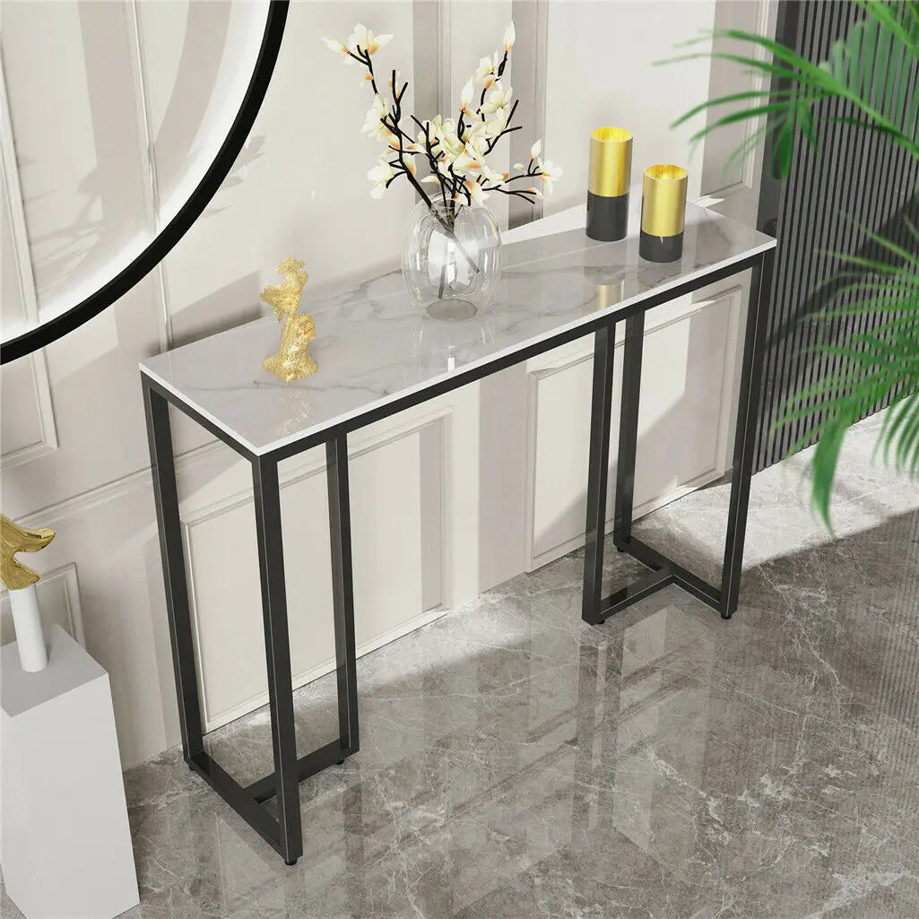 table console moderne marbre blanc pieds métal noir vase fleurs lampe livre plume dorée