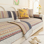 Ce canapé à motifs colorés et multicolores crée une atmosphère chaleureuse et accueillante dans cette pièce, avec ses coussins aux motifs de fleurs et de papillons qui ajoutent une touche de fantaisie.