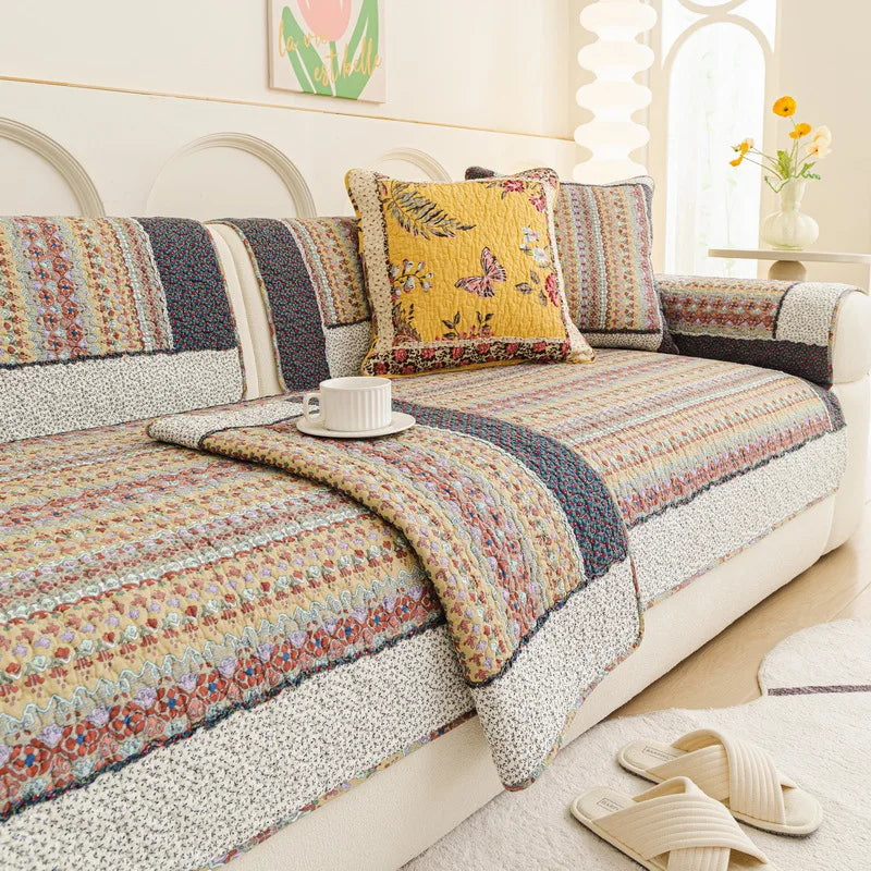 Ce canapé à motifs colorés et multicolores crée une atmosphère chaleureuse et accueillante dans cette pièce, avec ses coussins aux motifs de fleurs et de papillons qui ajoutent une touche de fantaisie.