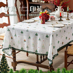 Une nappe de table joliment décorée avec des motifs d'arbres de Noël et de boules de Noël, créant une ambiance festive et chaleureuse pour le réveillon.