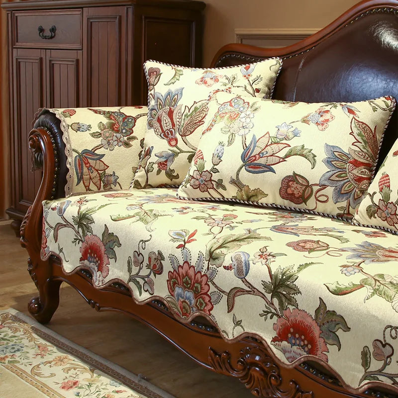 Un canapé en bois sculpté avec un motif floral coloré et détaillé sur un tissu beige.