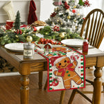 La table décorée présente un arbre de Noël, des guirlandes de houx, des plats de fruits rouges et des objets décoratifs de Noël, offrant une ambiance chaleureuse et festive.