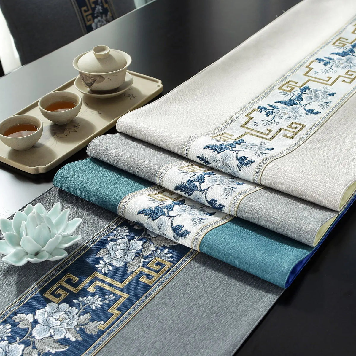 Une table élégante avec une vaisselle traditionnelle et des textiles ornés de motifs floraux bleus et blancs, créant une atmosphère apaisante.