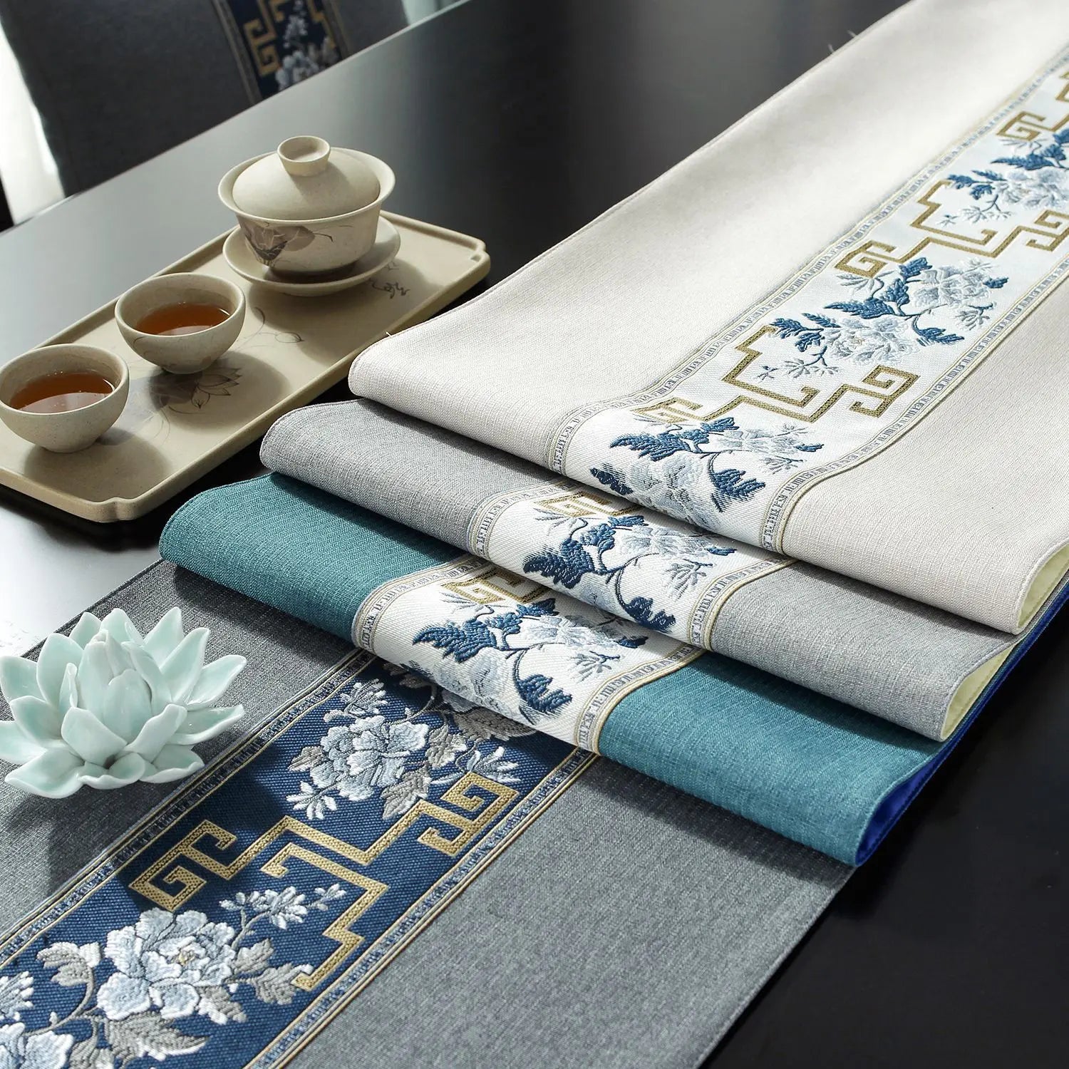 Une table élégante avec une vaisselle traditionnelle et des textiles ornés de motifs floraux bleus et blancs, créant une atmosphère apaisante.