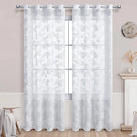 Voilage blanc à motifs papillons retenu par des embrasses décoratives, devant une porte-fenêtre.