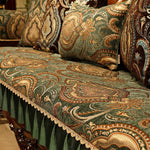 Riche tissu décoratif aux motifs floraux et arabesques traditionnels dans des tons verts, bruns et dorés, créant une ambiance chaleureuse et élégante.