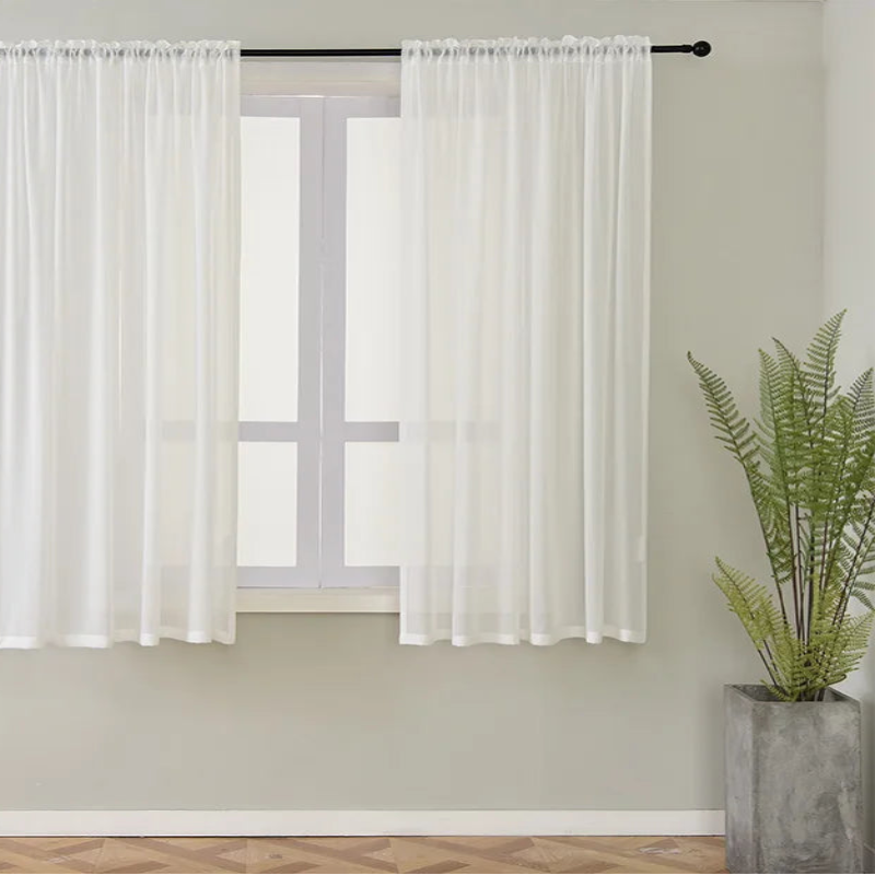 Image de rideaux luxueux, suspendus à une tringle en acier inoxydable, avec des embrasses assorties, constituant un traitement de fenêtre élégant et moderne pour améliorer la décoration intérieure et assurer l'intimité.