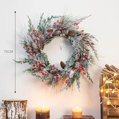 Couronne de Noël artificielle pomme de pin avec baies rouges suspendue à une porte