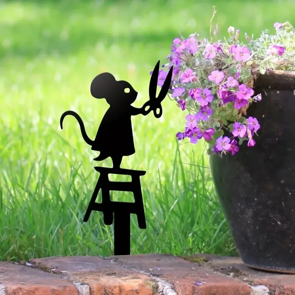 Sculpture métal souris dans un jardin décoratif avec plantes