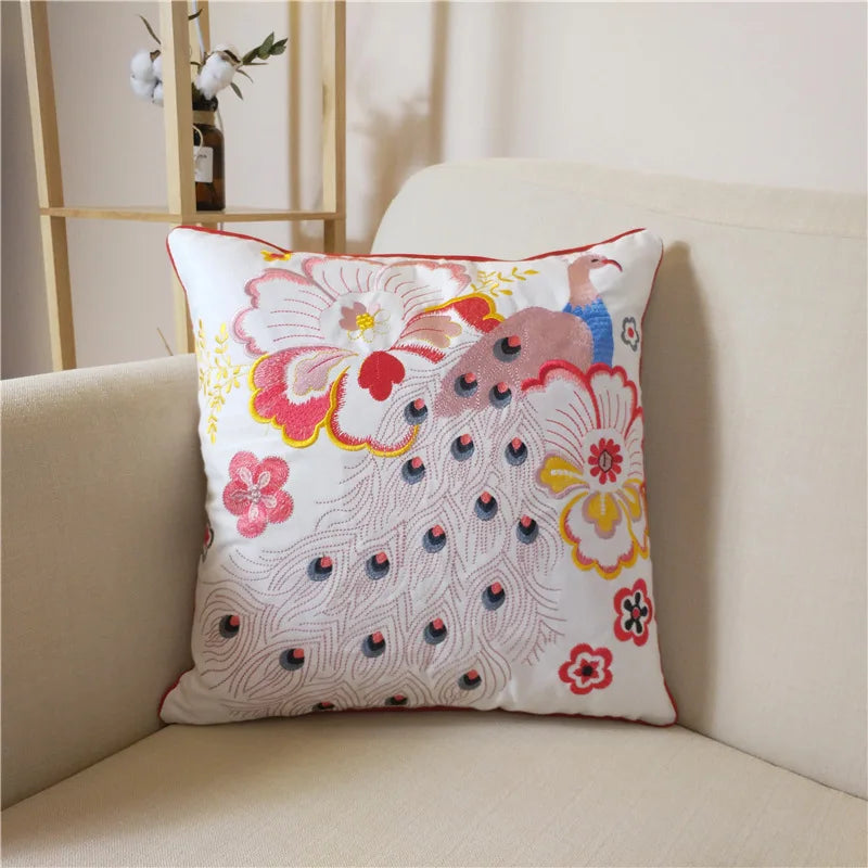 Coussin décoratif coloré avec un motif floral et un paon stylisé.