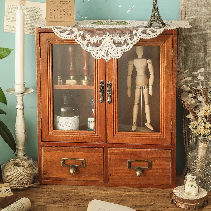 armoire vintage deux portes vitrées deux tiroirs bois marron clair verres transparents objets rangement