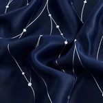 Tissu décoratif bleu marine avec motif géométrique blanc, idéal pour la confection de vêtements élégants. Design moderne parfait pour des tenues sophistiquées.