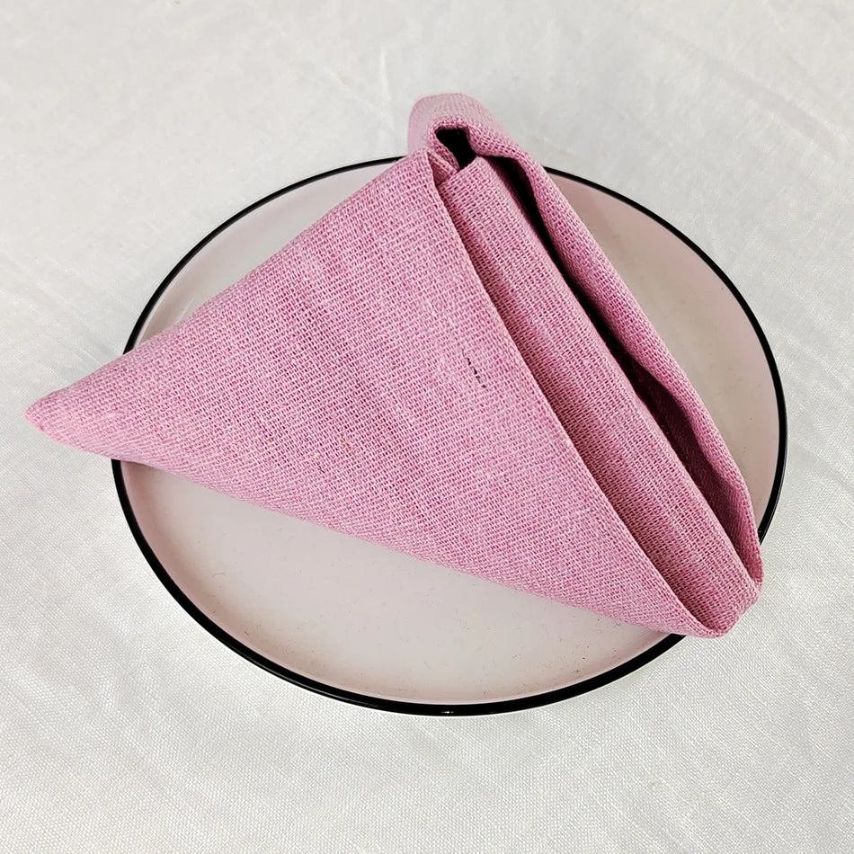 Cet image présente un foulard rose tricoté, placé sur un plateau noir, créant un contraste élégant et simple.
