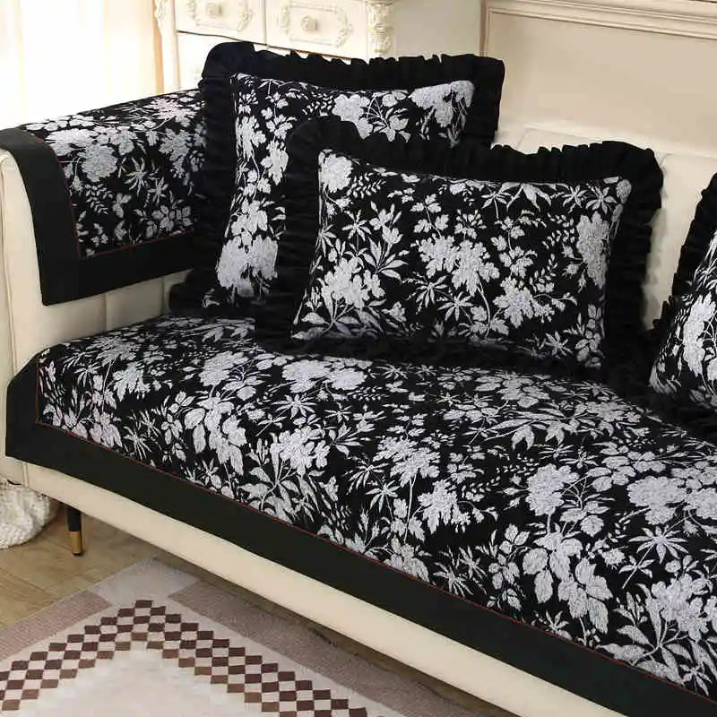 Parure de lit noire et blanche à motifs floraux avec coussins assortis, créant une atmosphère élégante et sophistiquée dans cette pièce.