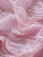 Texture en soie rose avec des plis délicats et une inscription élégante.