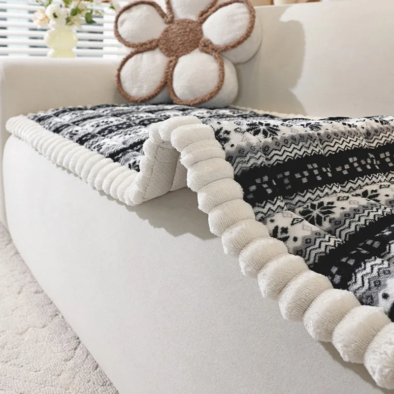 Coussin décoratif moelleux avec motifs géométriques et fleurs stylisées, sur une surface blanche de canapé ou lit.