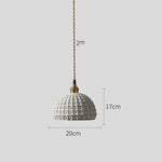 Lampe suspendue éclairant un salon moderne avec canapé gris