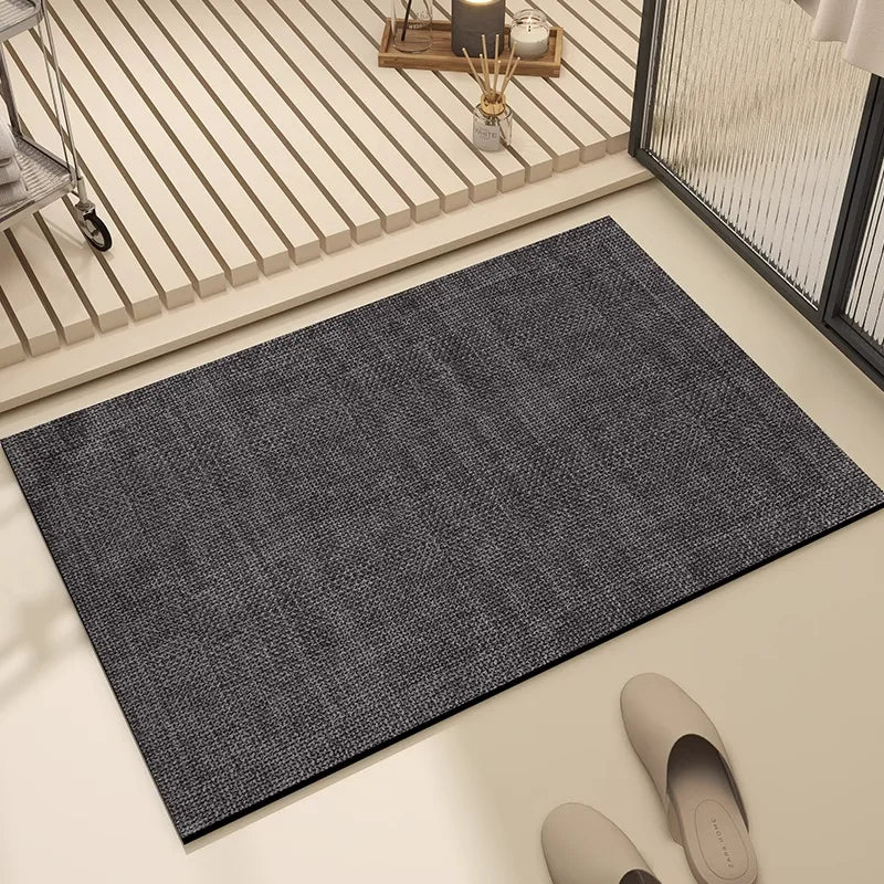Tapis de sol gris foncé posé dans un lieu intérieur lumineux, avec des éléments de décoration et des chaussures sur le côté.