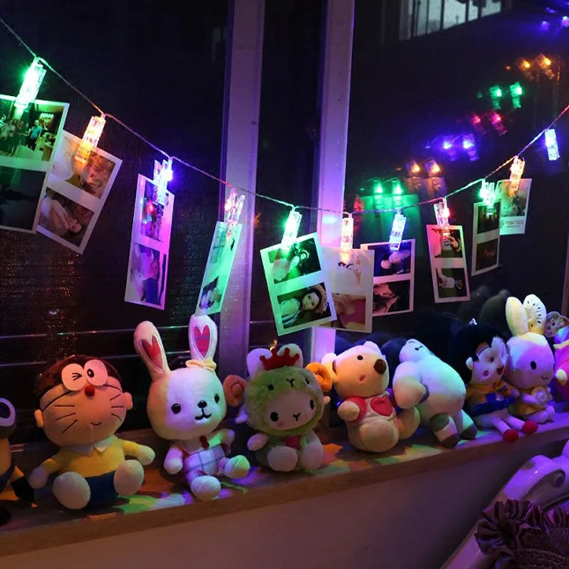 Détail des clips de la guirlande LED accrochant des photos sur un mur