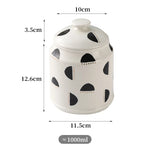 Pot de rangement en céramique blanche avec motifs noirs ronds et pointillés, d'une capacité approximative de 1000 ml.