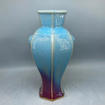 Vase décoratif aux couleurs bleu et rouge iridescent, avec un design géométrique distinctif.