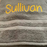 Détail de la broderie à la main sur serviette de bain personnalisée