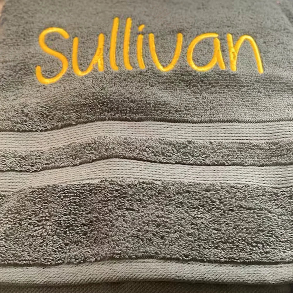 Détail de la broderie à la main sur serviette de bain personnalisée