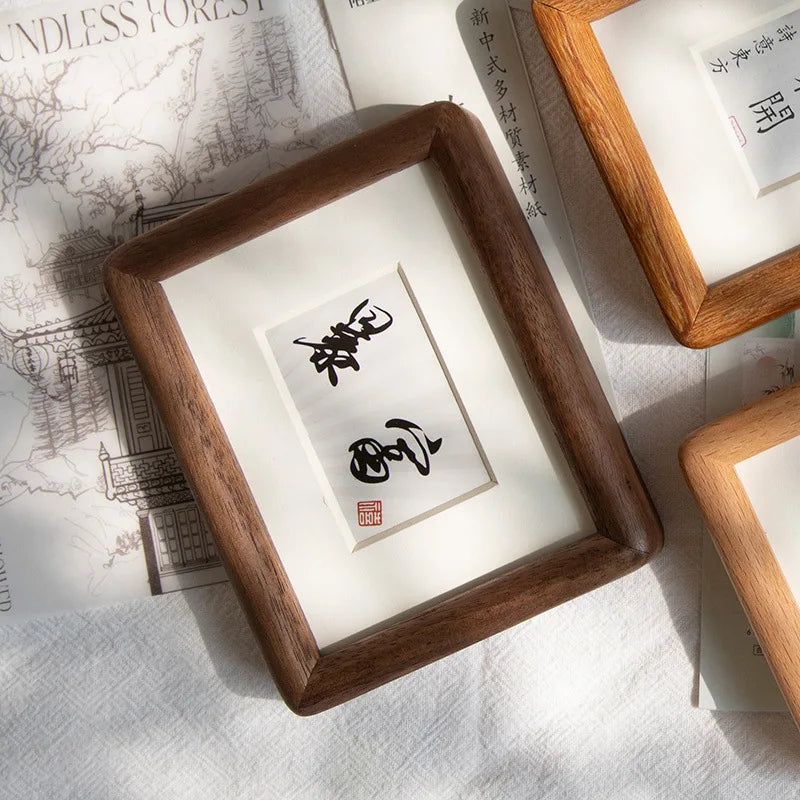 cadre photo bois marron foncé pouces dorés papier blanc mat calligraphie noire minimaliste decoration