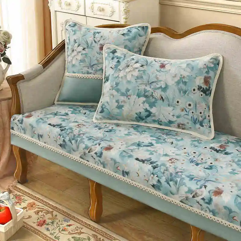 Un canapé vintage aux teintes pastel orné de motifs floraux délicats, assorti de coussins assortis, crée une ambiance élégante et romantique dans cette pièce meublée avec soin.