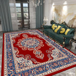 Un riche tapis persan aux motifs floraux et ornements bleus et rouges, décorant une pièce élégante avec un canapé en cuir vert et des accessoires de style victorien.