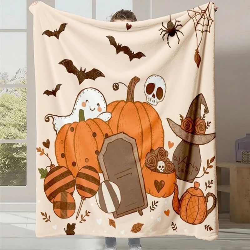 Une couverture confortable et festive, ornée de citrouilles, de fantômes et de chauves-souris, créant une ambiance cosy et halloween pour la saison.
