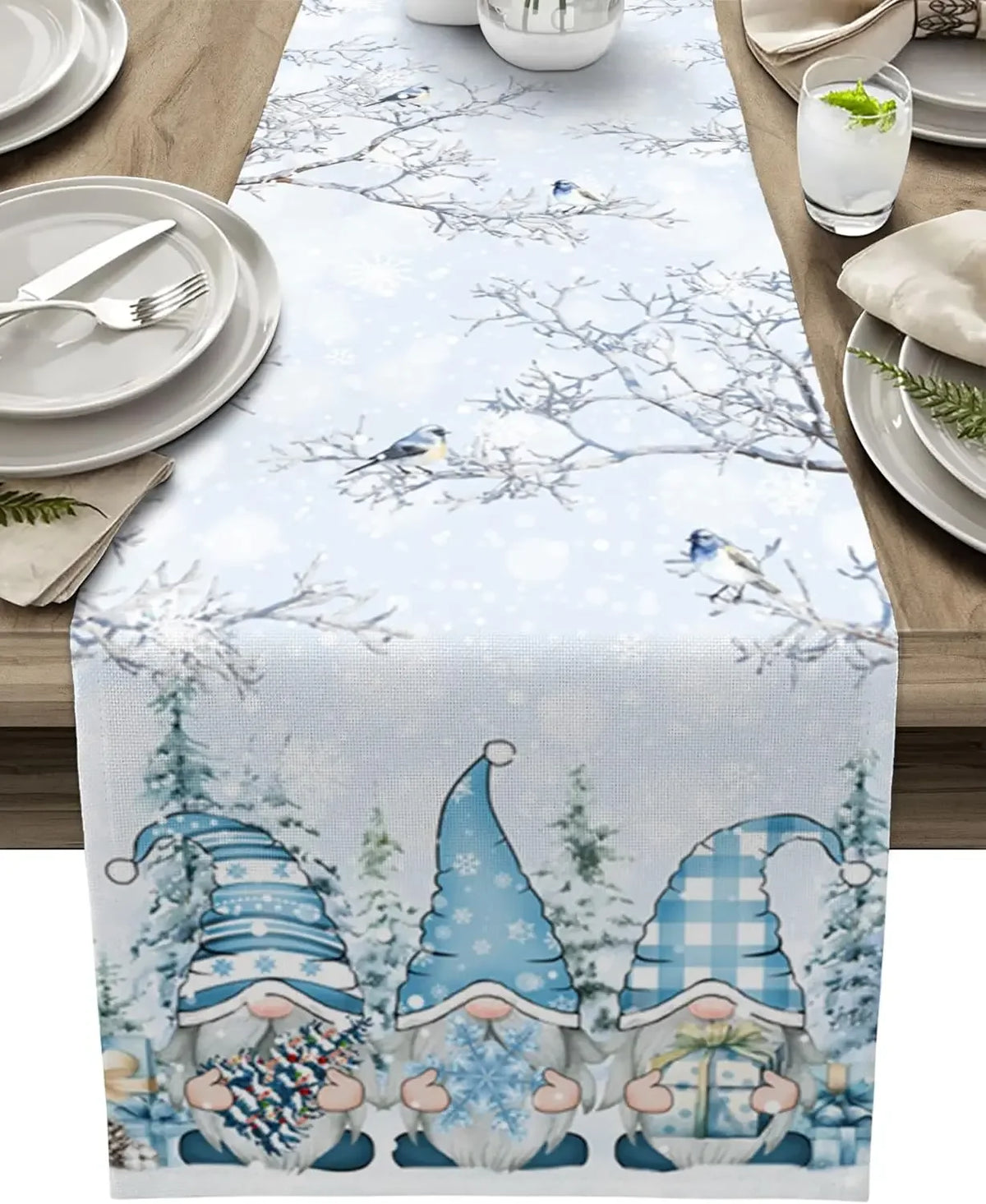 Un chemin de table hivernal orné de gnomes aux chapeaux colorés sur un paysage enneigé avec des oiseaux.