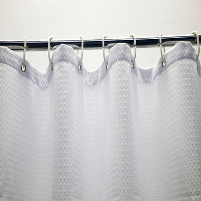 Rideau de douche en maille blanche, ajoutant une touche moderne et élégante à une salle de bain équipée de fixtures de plomberie. Idéal pour compléter n'importe quel décor de salle de bain avec son design unique.