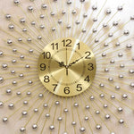 horloge murale moderne or sphères métalliques rayonnantes cadran lisse aiguilles noires salon déco