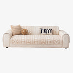 Canapé élégant avec des motifs géométriques beiges et un coussin décoratif noir, créant un style moderne et confortable.