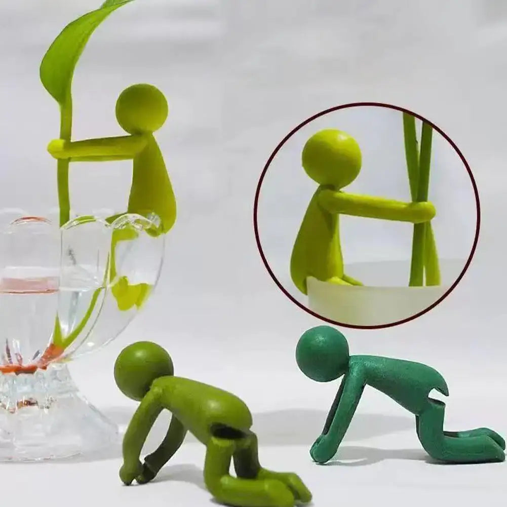 supports plantes figurines personnages stylisés verres transparents bambou feuilles philodendron fleurs blancs bleus