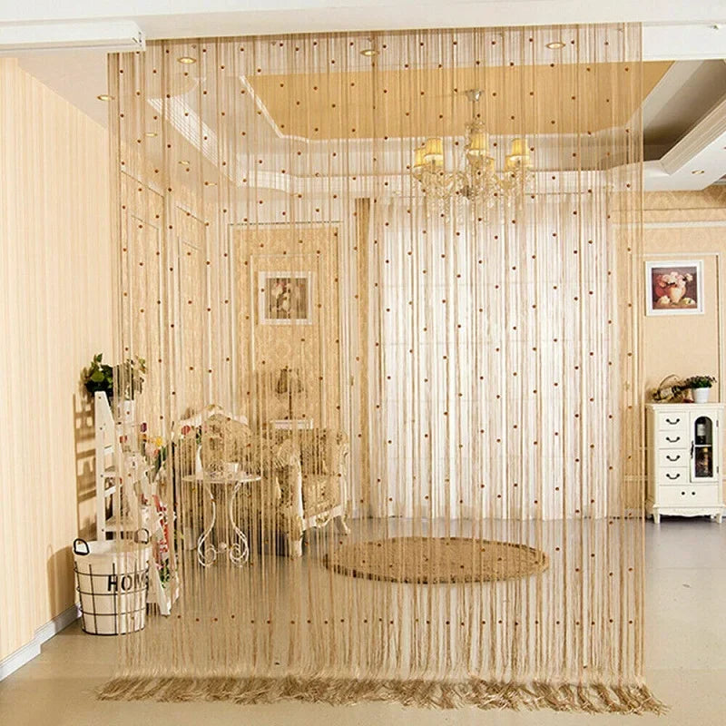 Rideau de perles noir utilisé comme séparateur de pièce dans un salon