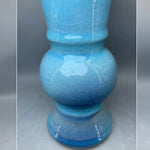 Vase en céramique bleu glacé avec motif abstrait et texturé, présentant des nuances dégradées de bleu.