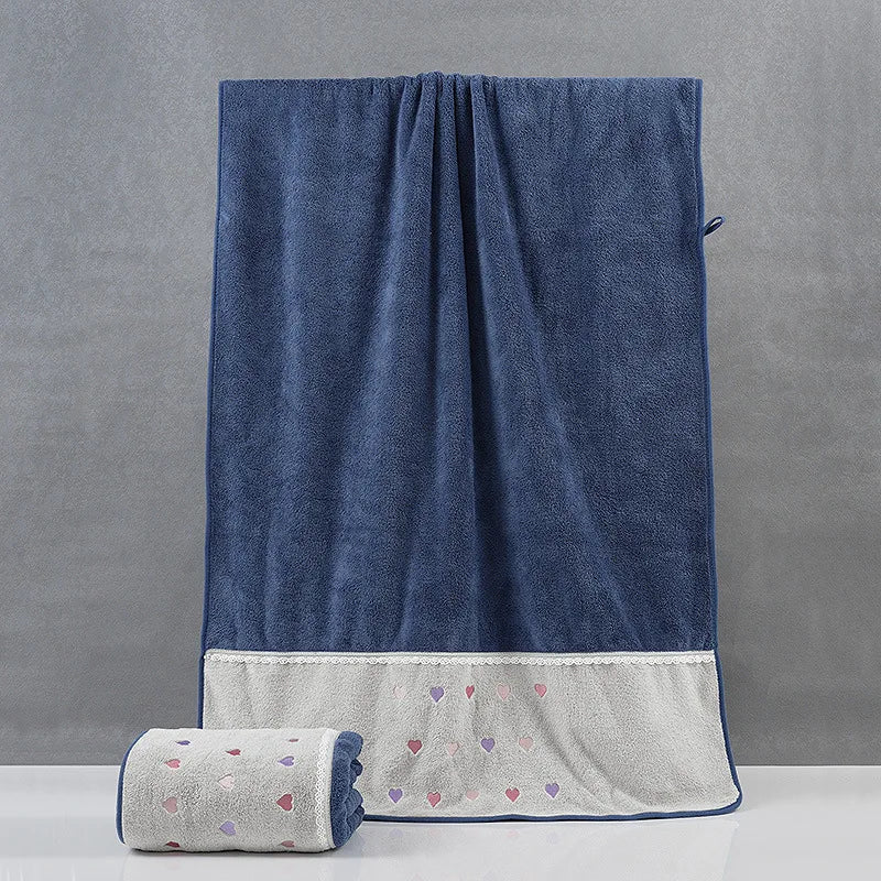 Couverture en velours bleu marine avec une bordure en coton imprimée de petits coeurs colorés.